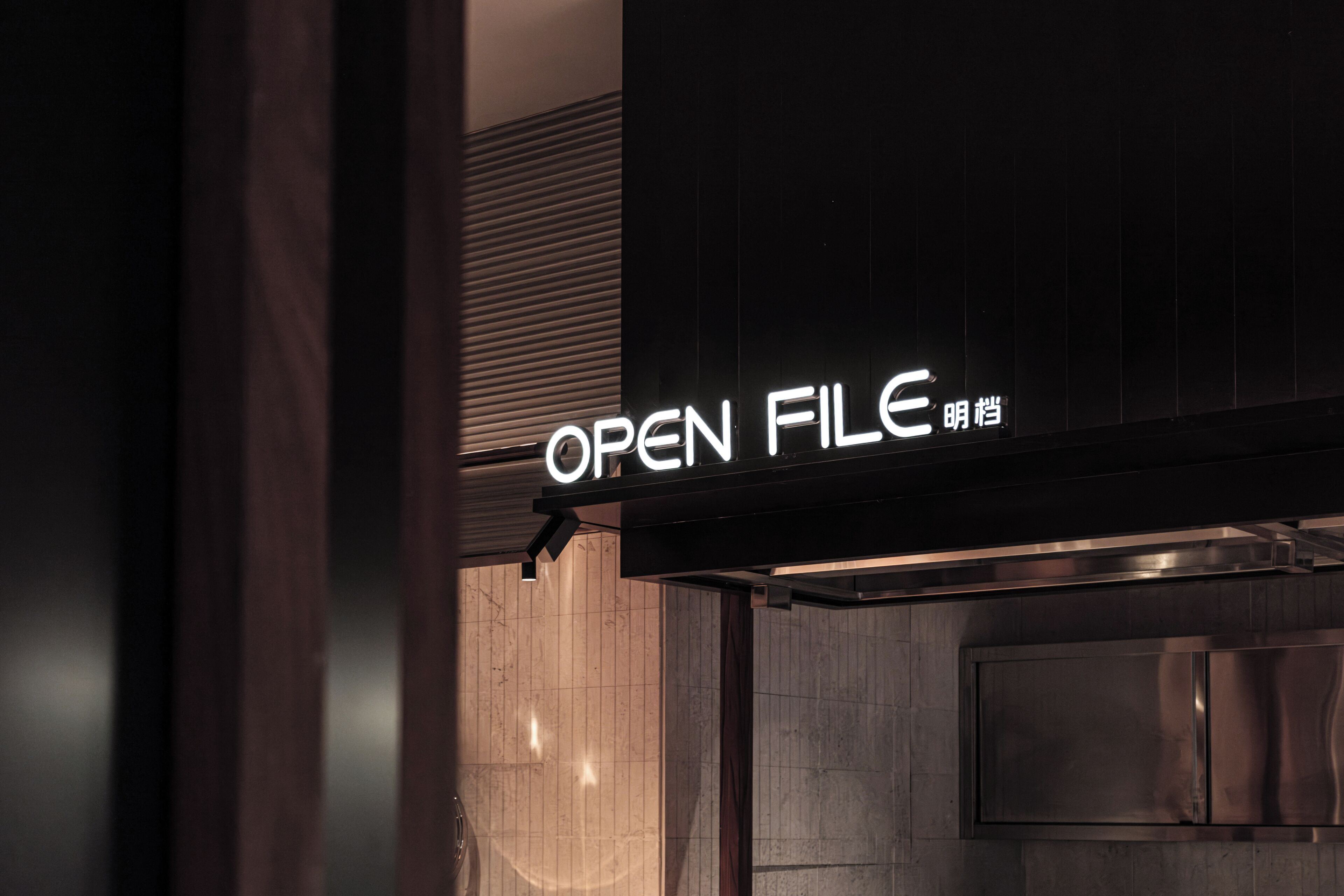 A sign with the text 'OPEN FILE' and a metallic structure.