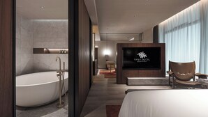 A modern hotel room with a large bathtub, a television, and a comfortable seating area. - Hangzhou Tipsy Hotel (Jinsha Lake) (Hangzhou)