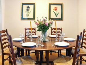 A dining table set for six with chairs, a vase with flowers, and framed botanical prints on the wall. - 3 bedroom accommodation in Near Bath (Bradford-on-Avon)