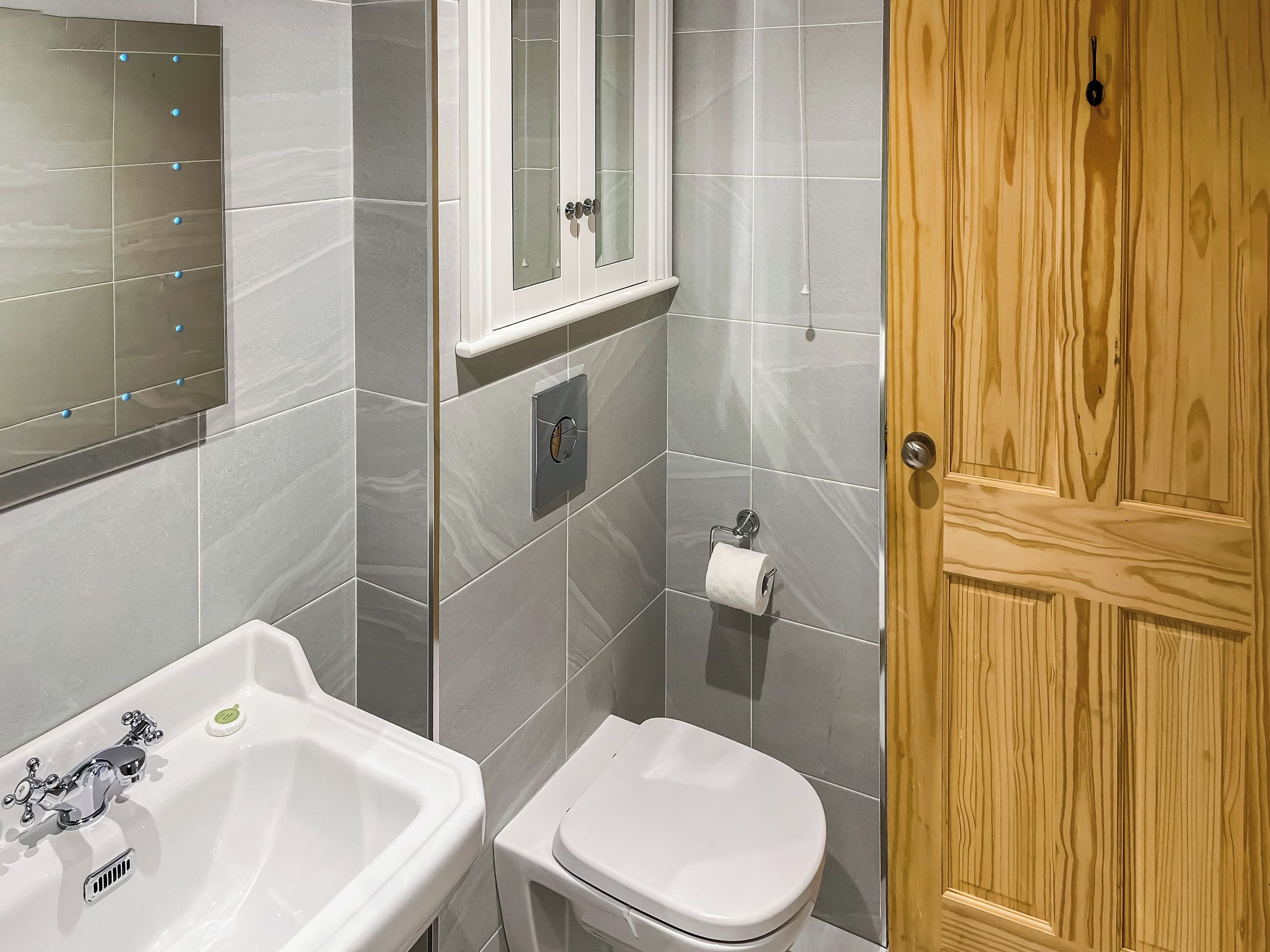 Une salle de bain avec un lavabo, des toilettes et un meuble de rangement.