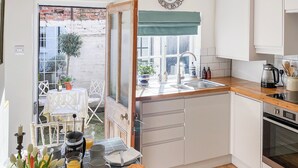A compact kitchen with a wooden countertop, a sink, and a built-in oven.
