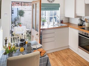 Una cocina compacta con encimera de madera, un lavabo y un horno empotrado.