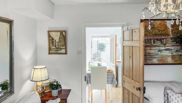 A cozy living room with a sofa, a lamp, and a painting.