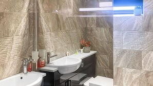 Un baño moderno con dos lavamanos, un inodoro y un espejo.