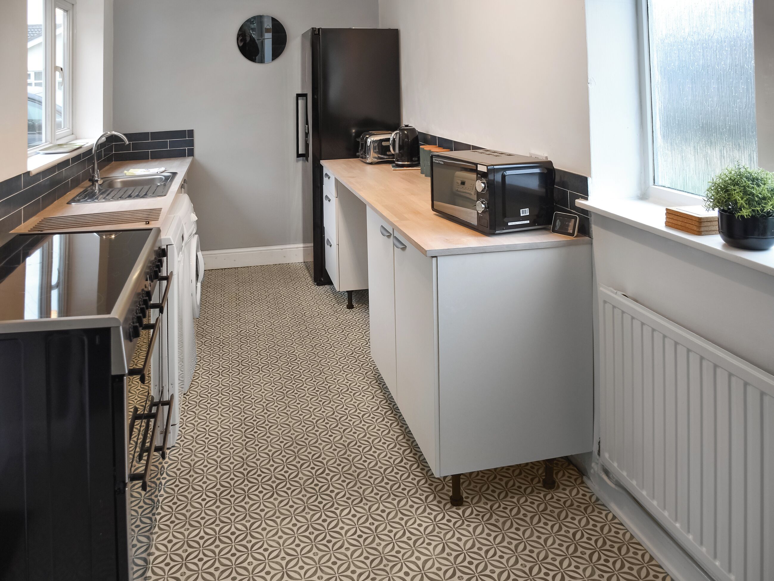 A compact kitchen with a microwave, toaster, and sink.
