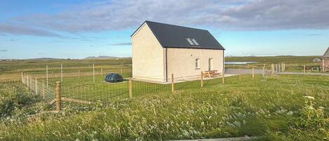 A small, single-story building with a sloped roof, a window, and a door.