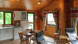 A wooden cabin interior with a kitchen, dining area, and seating. - The openness of the park and the closeness to the shore. (Acharacle, near Ardnamurchan)
