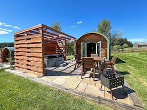 A wooden outdoor structure with a hot tub, seating area, and a covered patio. - Spruce Pod - UK51539 (Newton Stewart)