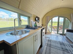 A kitchen with a sink, stove, and a view of the outdoors through a window. - 1 bedroom accommodation in Newton Stewart (Newton Stewart)
