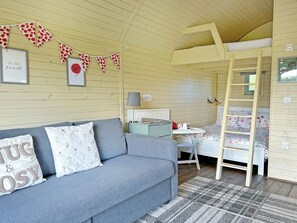 A cozy room with a sofa, a ladder, a desk, and a bunk bed. - Cosy glamping pod with private hot tub, double bed and sofa bed. (Newton Stewart)