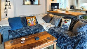 A cozy living room with a sofa, coffee table, and a TV. - 1 bedroom accommodation in Blunsdon (Blunsdon)