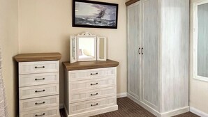 A bedroom with a bed, a dresser, a wardrobe, and a framed picture on the wall. - 3 bedroom accommodation in Trerulefoot (Trerulefoot)