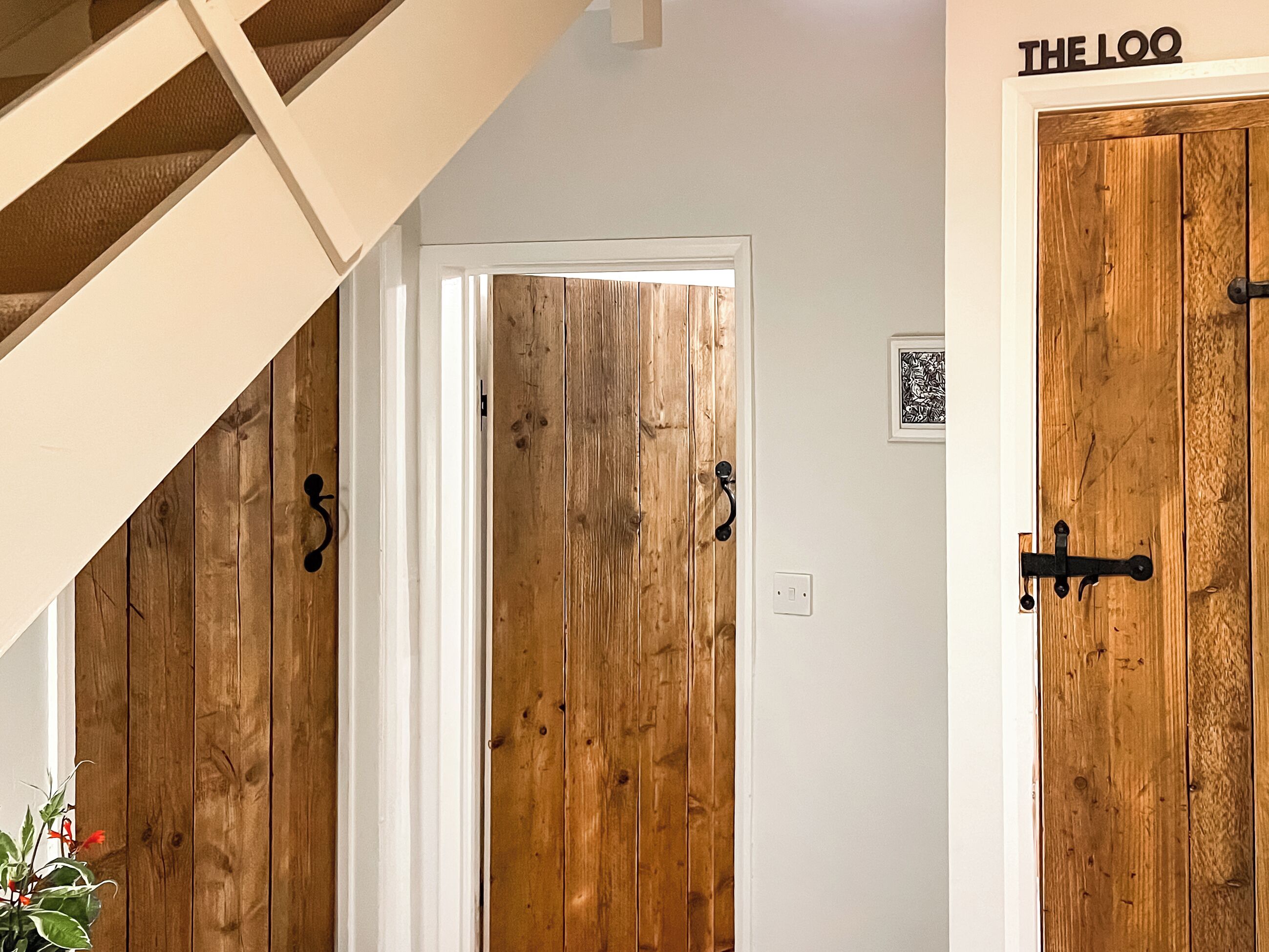 A wooden door with a metal handle and a sign above it.