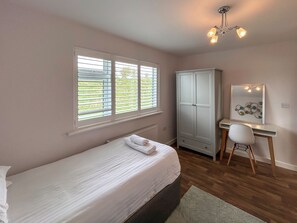 A bedroom with a bed, a desk, a wardrobe, and a mirror. - Fern Lodge - UK51604 (Sunset Lakes)