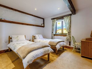 A bedroom with two wooden beds, a window with curtains, a chair, and a wooden cabinet. - 2 bedroom accommodation in Launceston (Launceston)