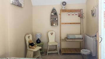 A room with bunk beds, a desk with a chair, a teddy bear, a lamp, and a radiator.