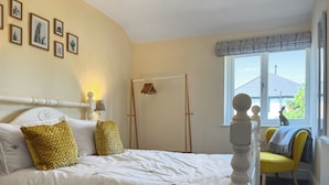 A bedroom with a bed, a window with a view, and a door.