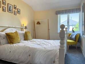 Un dormitorio con cama, ventana con vista y puerta.