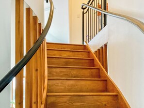 A wooden staircase with a metal handrail, white walls, and a wooden floor. - 1 bedroom accommodation in Ashmore, near Shaftesbury, (Ashmore, near Shaftesbury,)