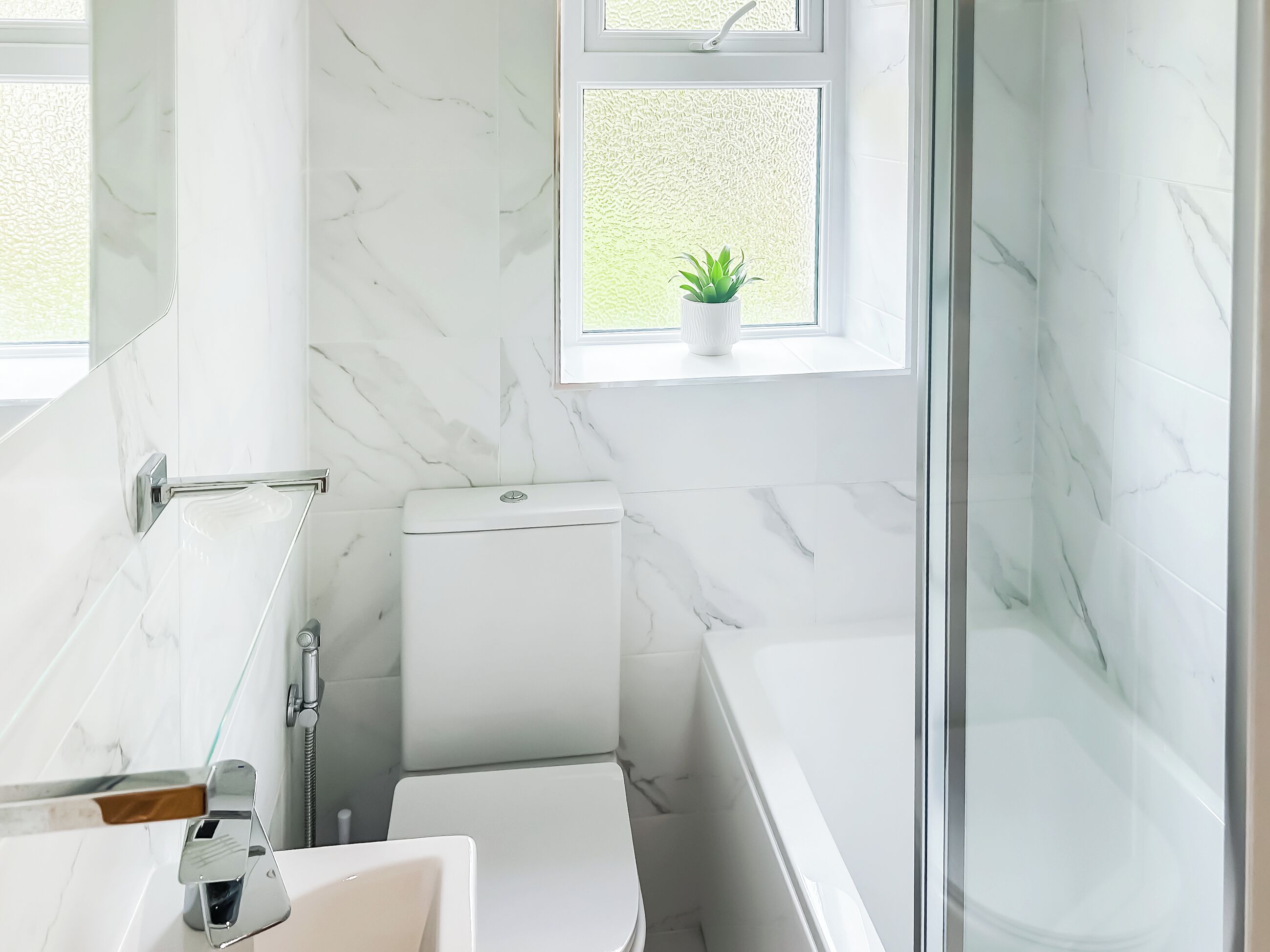 A bathroom with a toilet, sink, and shower area.