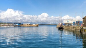 Un puerto con barcos, un muelle y un edificio con cajas apiladas.