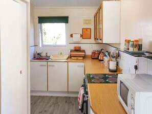 A compact kitchen with a microwave, toaster, and wooden countertop. - 2 bedroom accommodation in Newcastle Emlyn (Newcastle Emlyn)