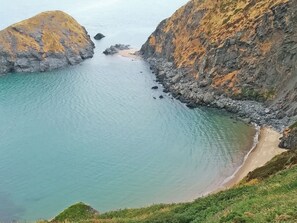 A coastal landscape with a clear view of the sea, rocky cliffs, and a sandy beach. - 2 bedroom accommodation in Newcastle Emlyn (Newcastle Emlyn)