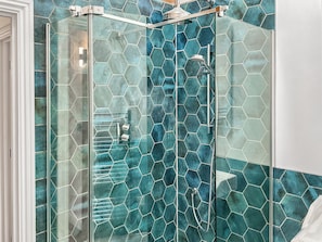 Eine Dusche mit Glastür und Regendusche.