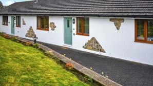A white building with a grey roof, stone accents, and green doors. - 1 bedroom accommodation in Tytherleigh, near Axminster (Tytherleigh, near Axminster)