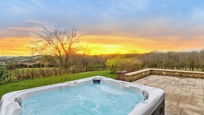 A hot tub in a garden with a sunset view. - 5 bedroom accommodation in Shepton Mallet (Shepton Mallet)