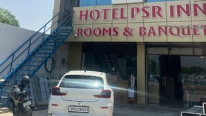 Ein Hotelgebäude mit einem Schild für 'Hotel PSR Inn' und 'Zimmer & Bankett'.