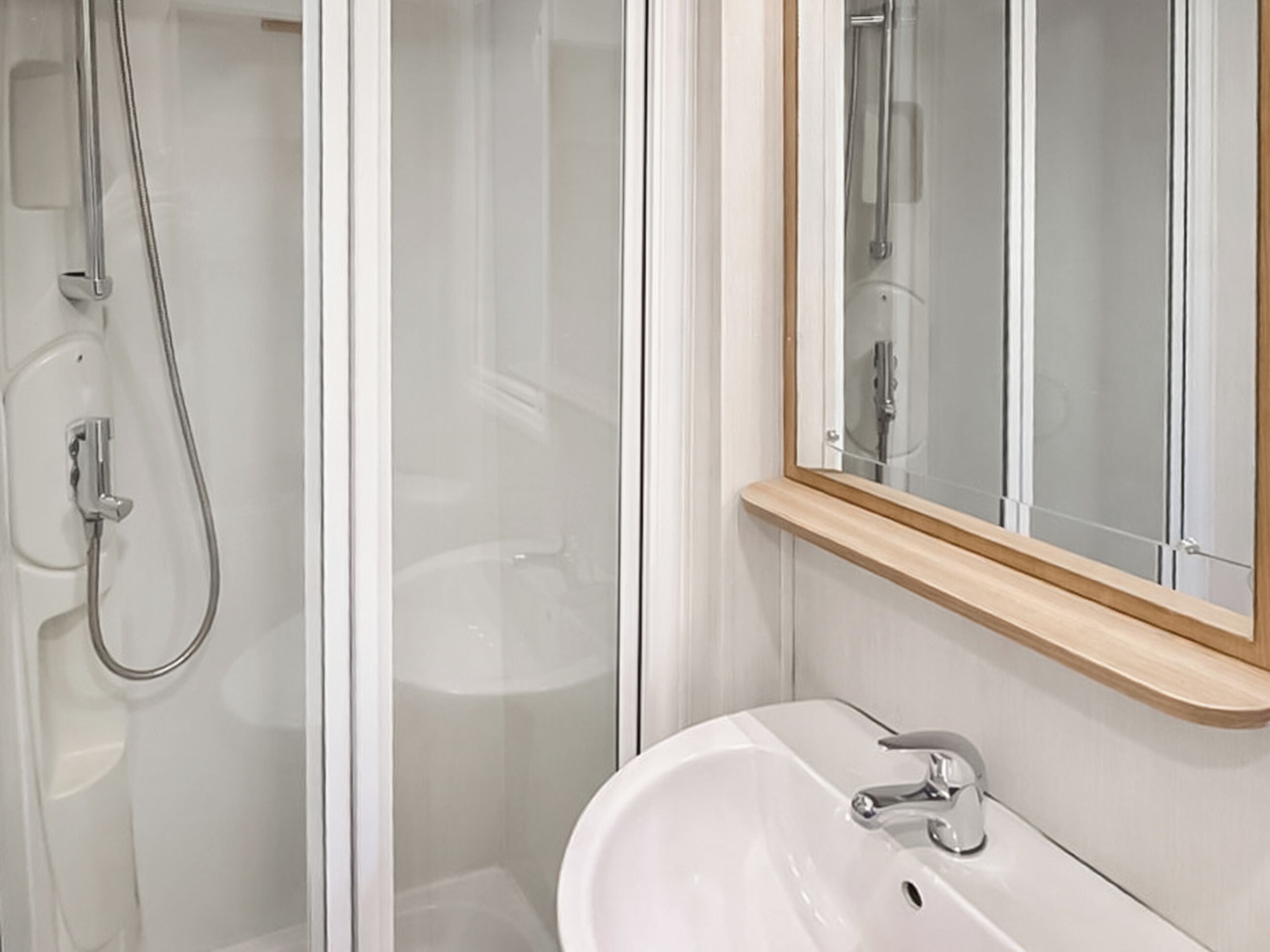A bathroom with a shower, a sink, and a mirror.