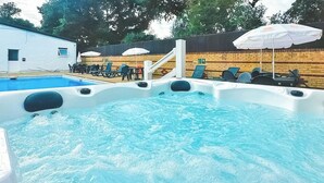Tinaco con piscina, sillas de descanso y sombrillas.