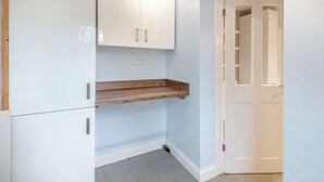 Ein Zimmer mit einem weißen Schrank, einem Holzboden und einer weißen Tür, wobei die Wand hellblau ist.