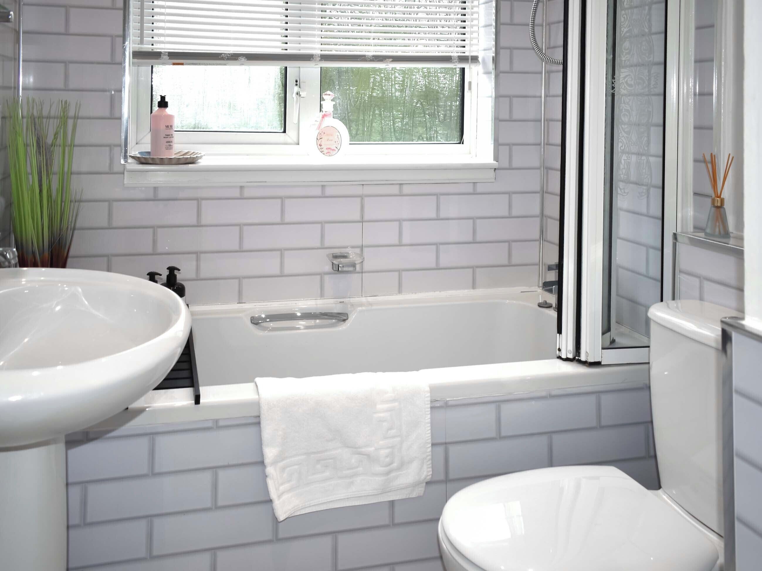 Een badkamer met een bad, een wastafel en een toilet.