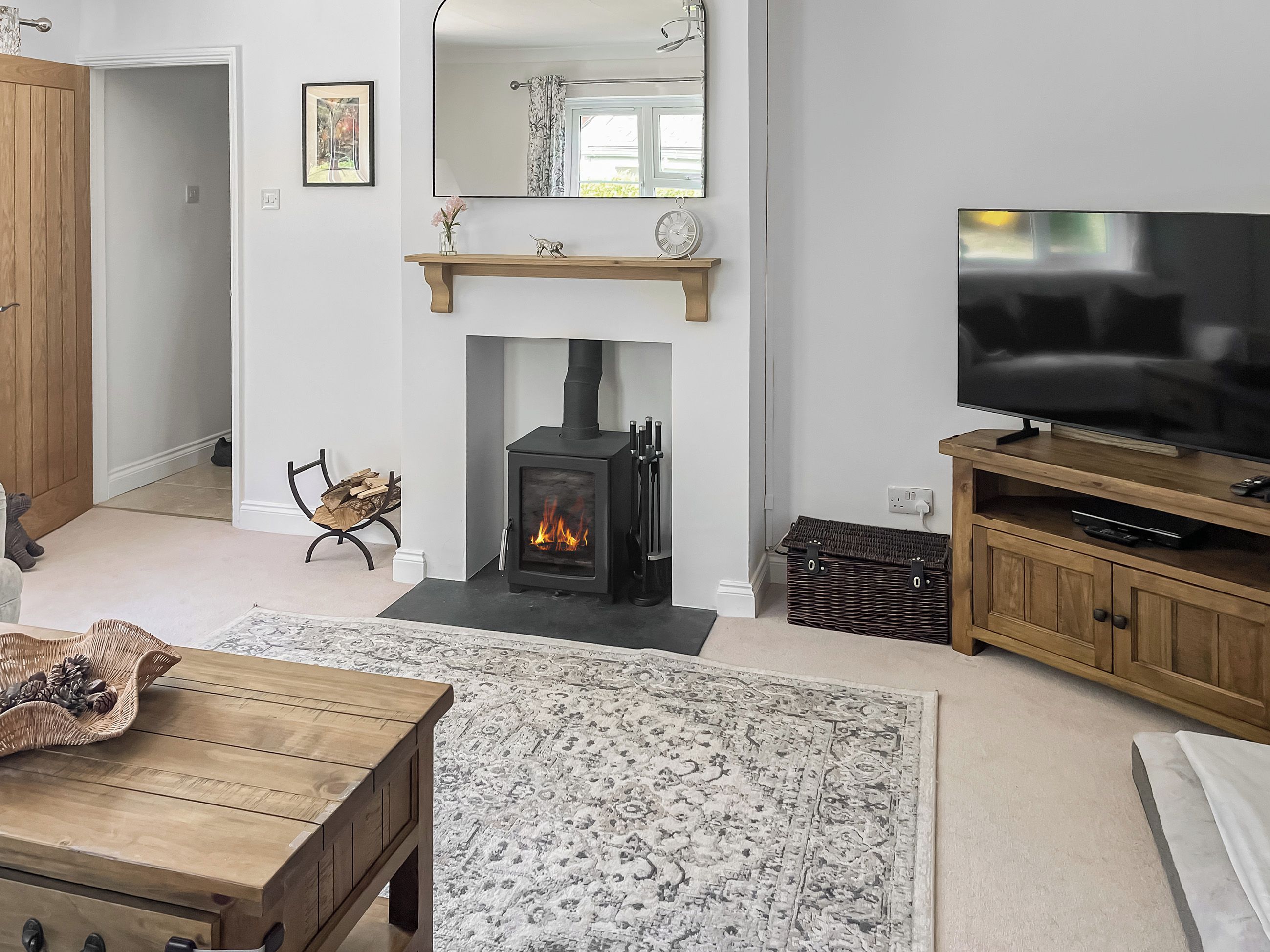 Una sala de estar con chimenea, televisor y una mesa de centro de madera.