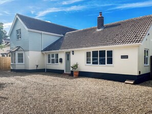 A two-story house with a grey siding exterior, a brown tiled roof, and a gravel driveway. - 4 bedroom accommodation in Hessett, near Bury St Edmunds (Hessett, near Bury St Edmunds)