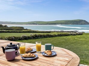 A table with breakfast items and a view of the ocean. - 6 bedroom accommodation in Trebetherick, near Wadebridge (Trebetherick, near Wadebridge)