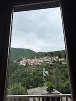 A view of a hillside village with buildings and greenery.