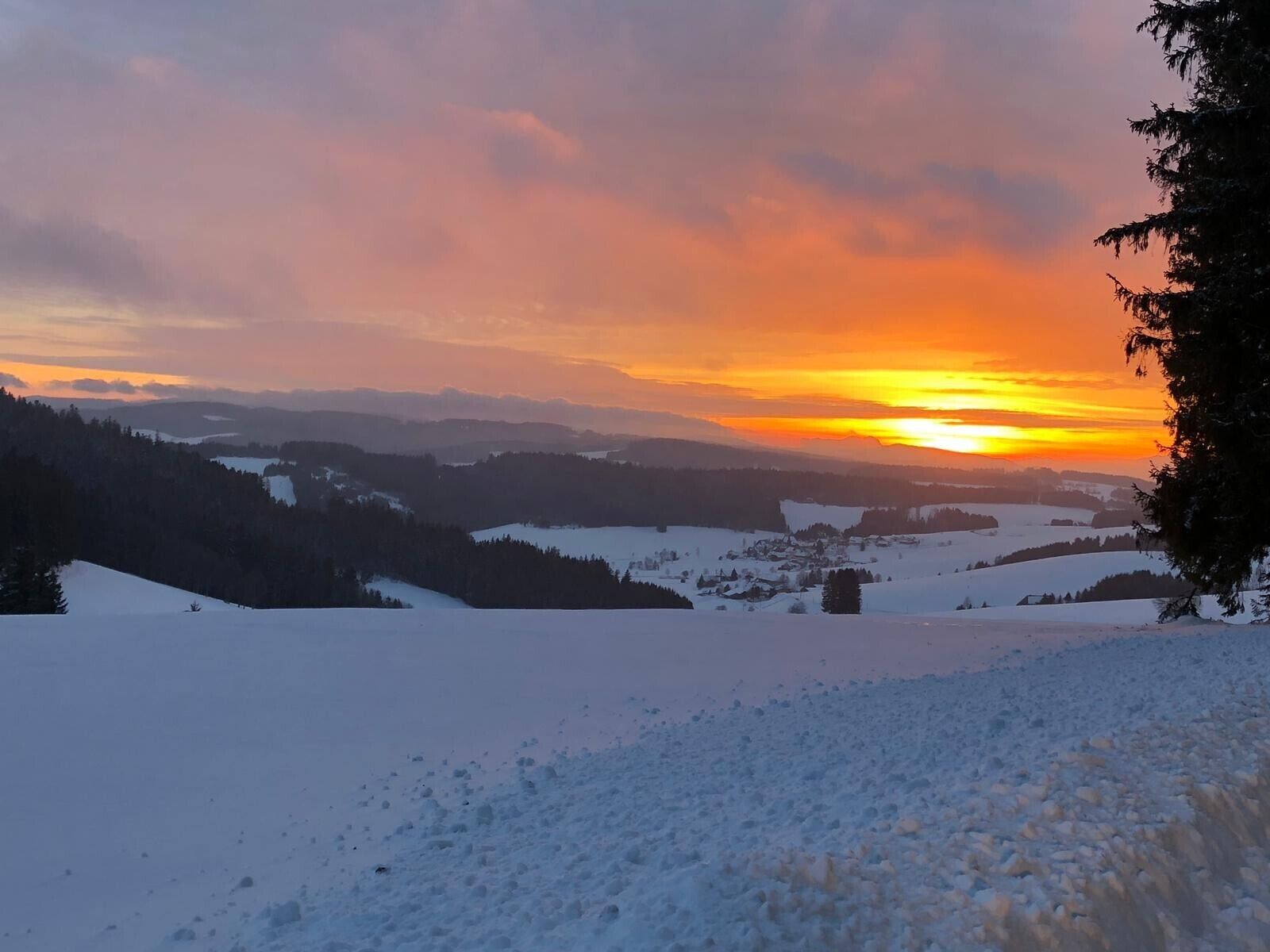 Eine verschneite Landschaft bei Sonnenuntergang.