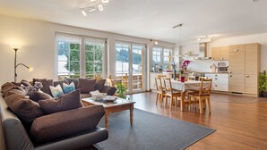A modern living room with a sofa, coffee table, and dining area.