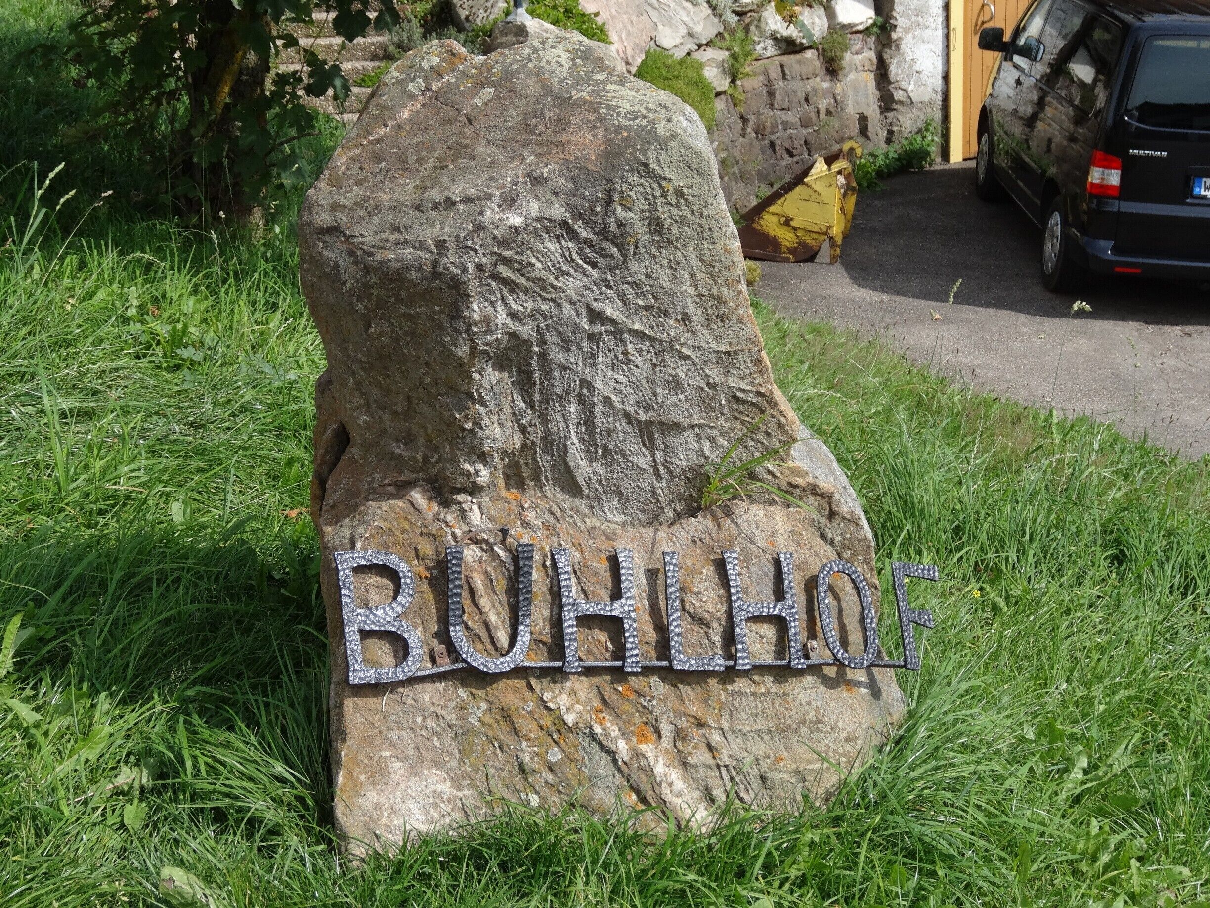 Ein großer Felsen mit der Aufschrift 'BOHLHAUS' aus Metalllettern.
