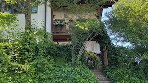 Una casa con una escalera de piedra que da a un balcón de madera.