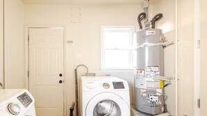 A laundry room with a washing machine, a dryer, and a water heater. - Furnished 3BR in Tracy, Comfortable longer stays (Tracy)