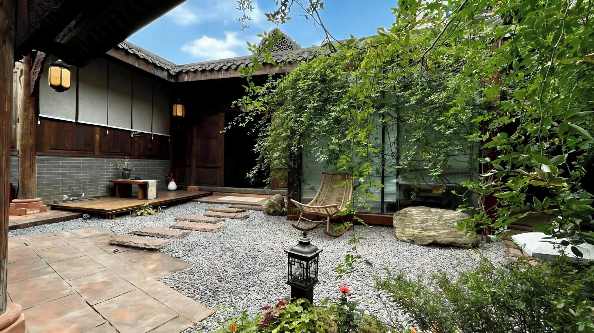 A traditional Japanese-style garden with a wooden building, a rock garden, and a seating area.