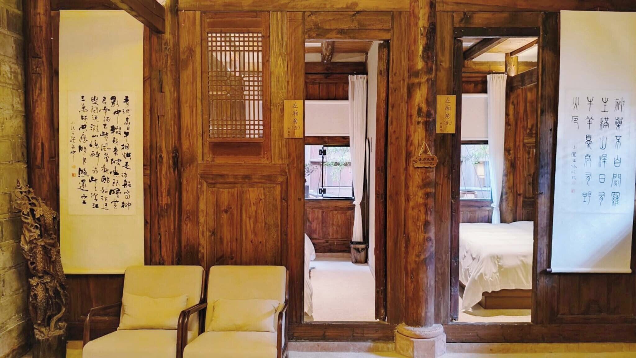 Een traditionele Japanse kamer met houten balken, tatami matten en kalligrafie op de muren.