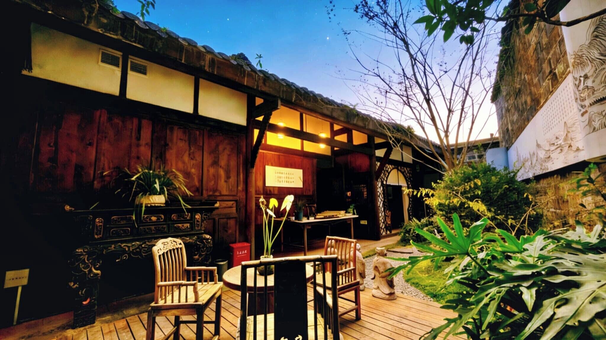 A traditional Japanese-style building with tatami mat flooring, wooden furniture, and a garden area.