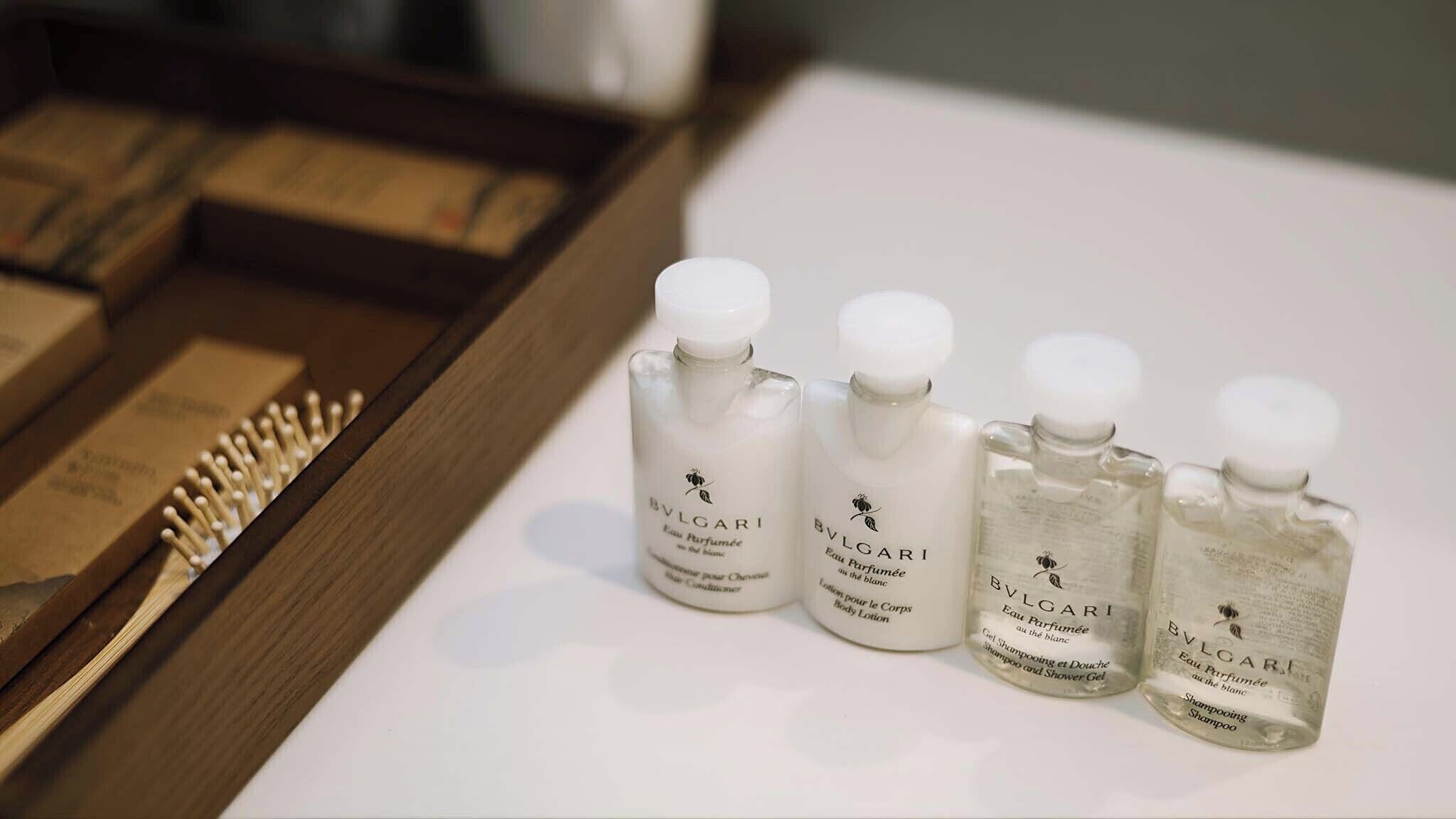 Vier Flaschen BVLGARI Körperlotion und Shampoo auf weißem Untergrund.