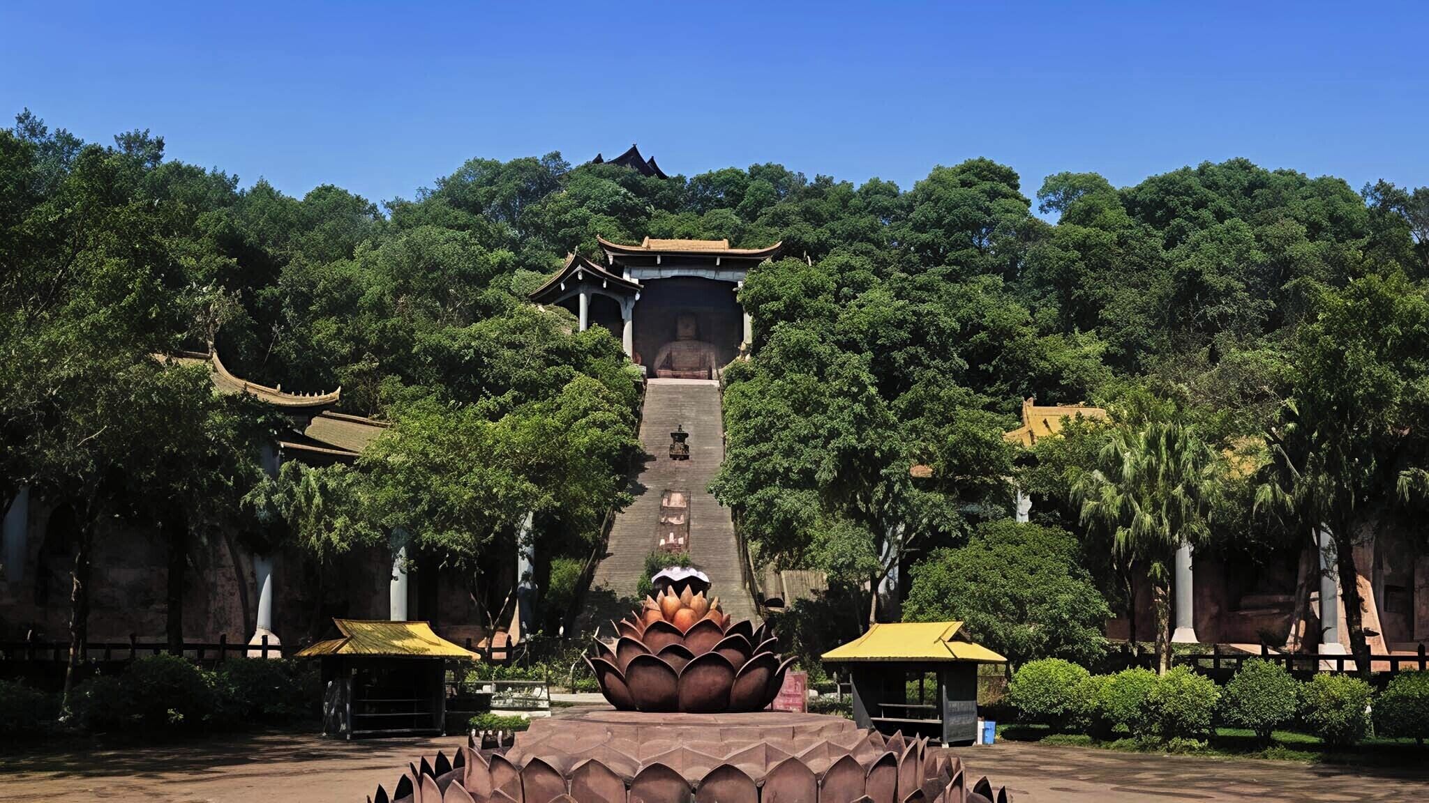 A traditional pagoda with a lotus base, surrounded by lush greenery and traditional architecture.