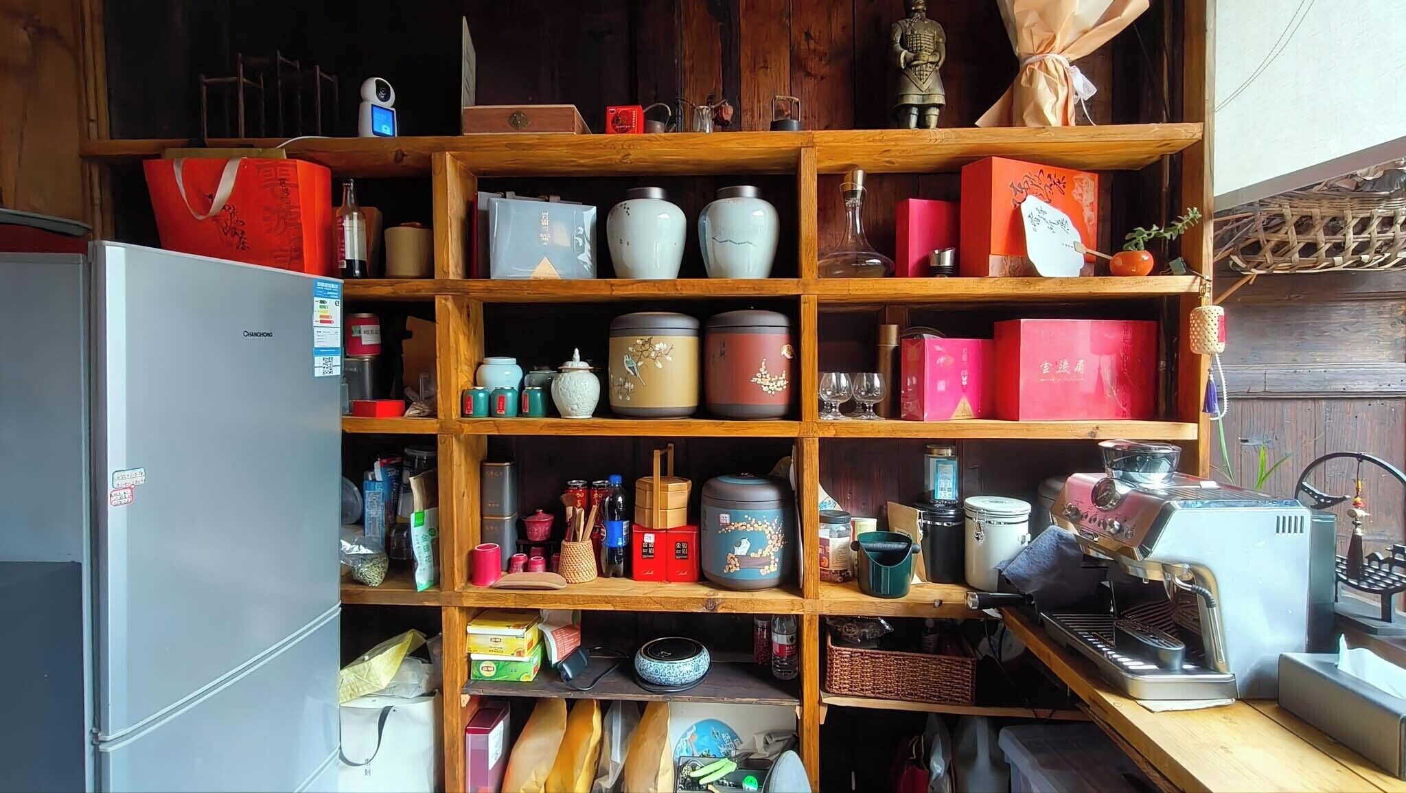 Una cocina con estantes de madera, utensilios de cocina y electrodomésticos.